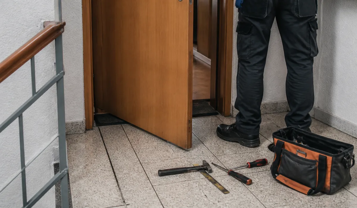 Opening a flat door in Barcelona, locksmith tools beside the cylinder, no faces towards the camera.